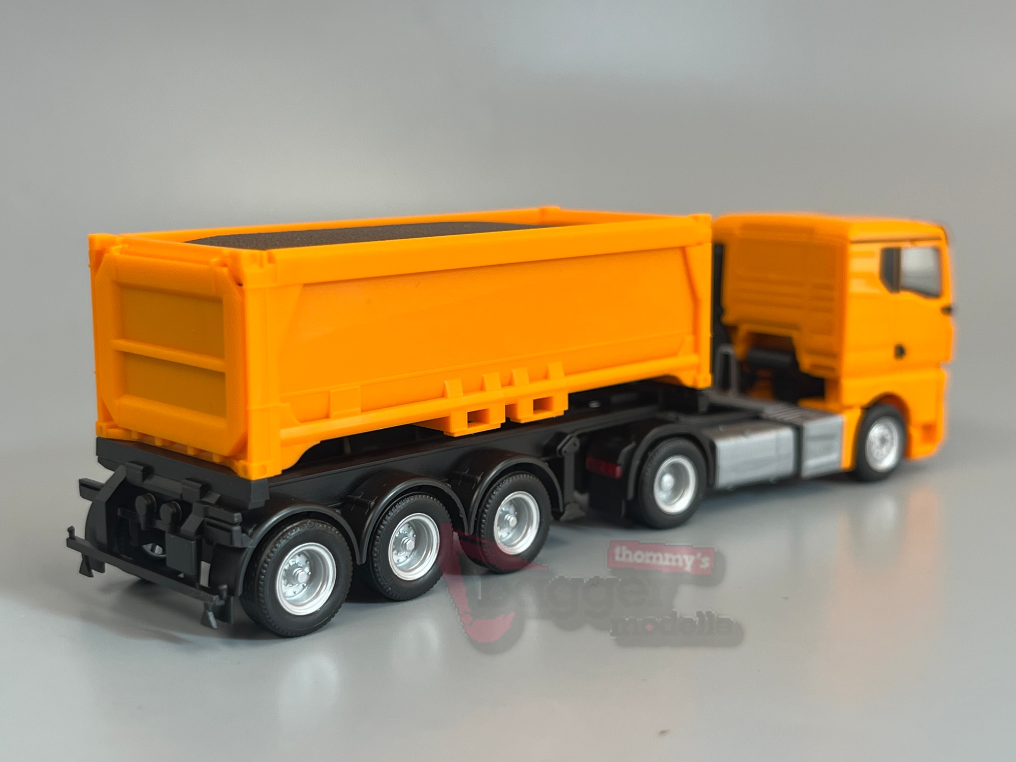 321310 - Herpa - MAN TGX GN Abraummulden-Sattelzug mit Ladegut, kommunalorange