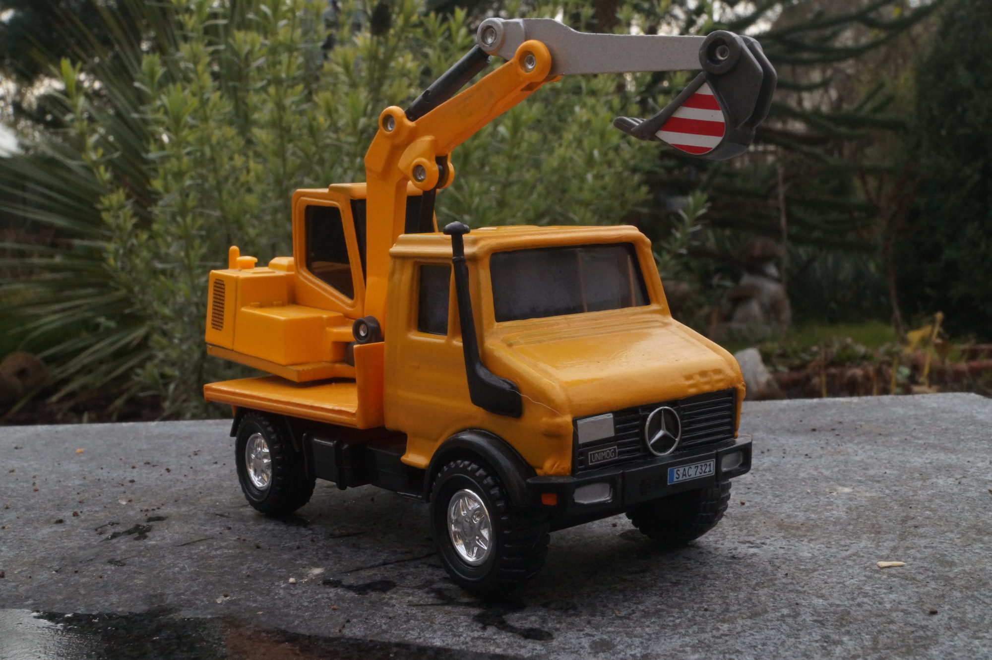 Mercedes Unimog Pritsche mit Bagger