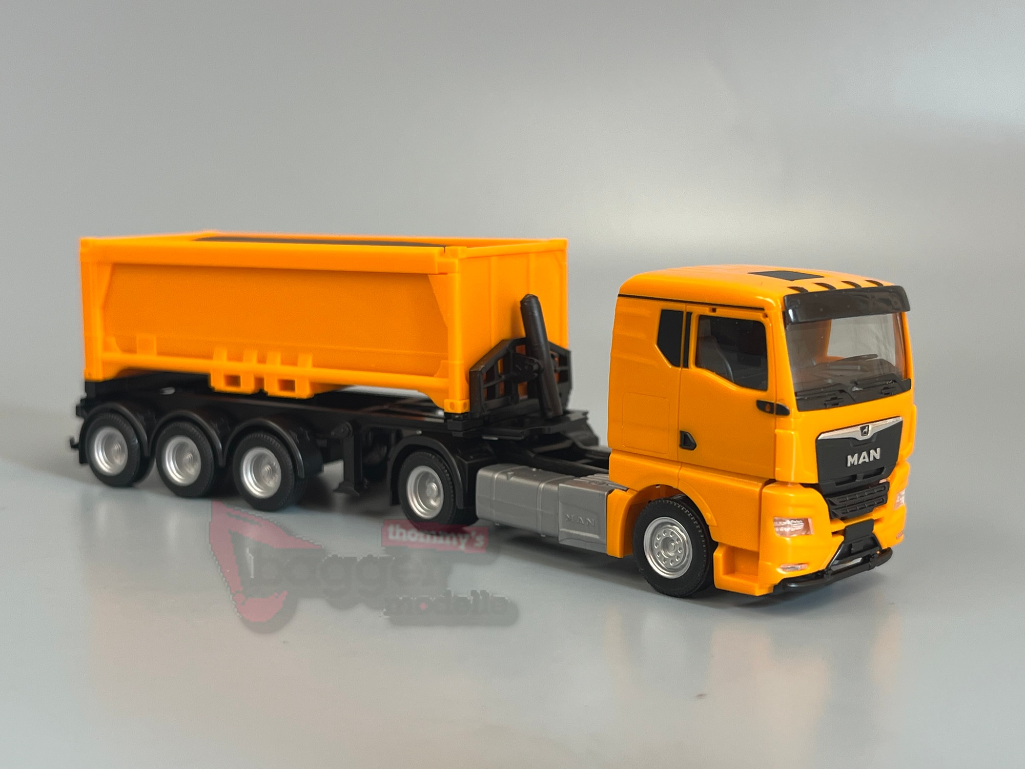 321310 - Herpa - MAN TGX GN Abraummulden-Sattelzug mit Ladegut, kommunalorange 