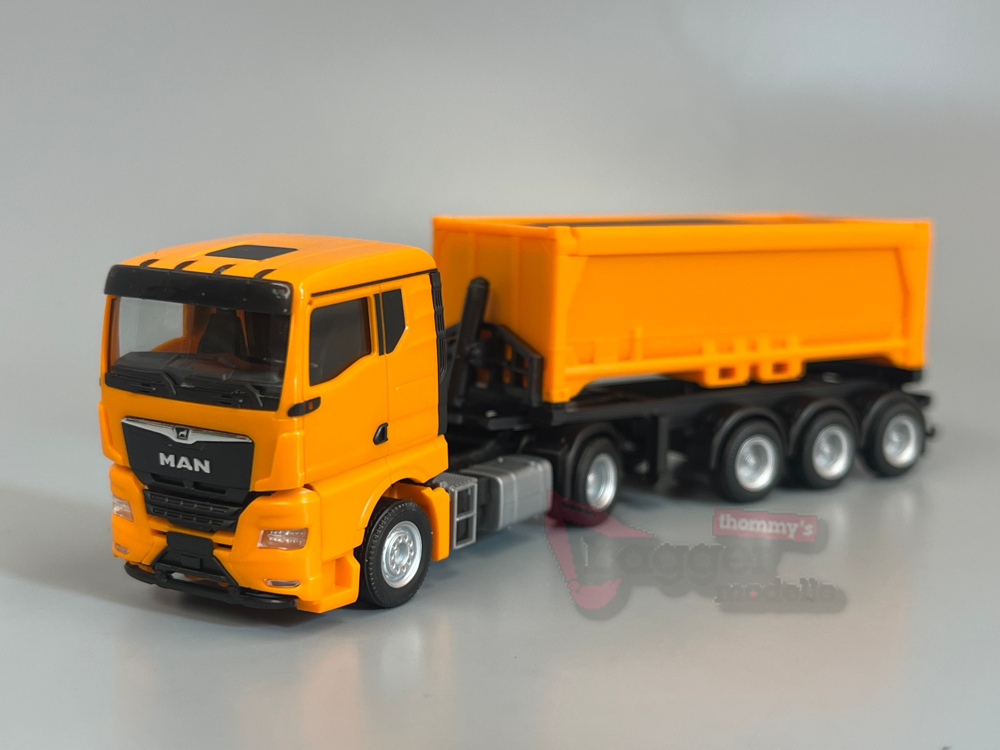 321310 - Herpa - MAN TGX GN Abraummulden-Sattelzug mit Ladegut, kommunalorange