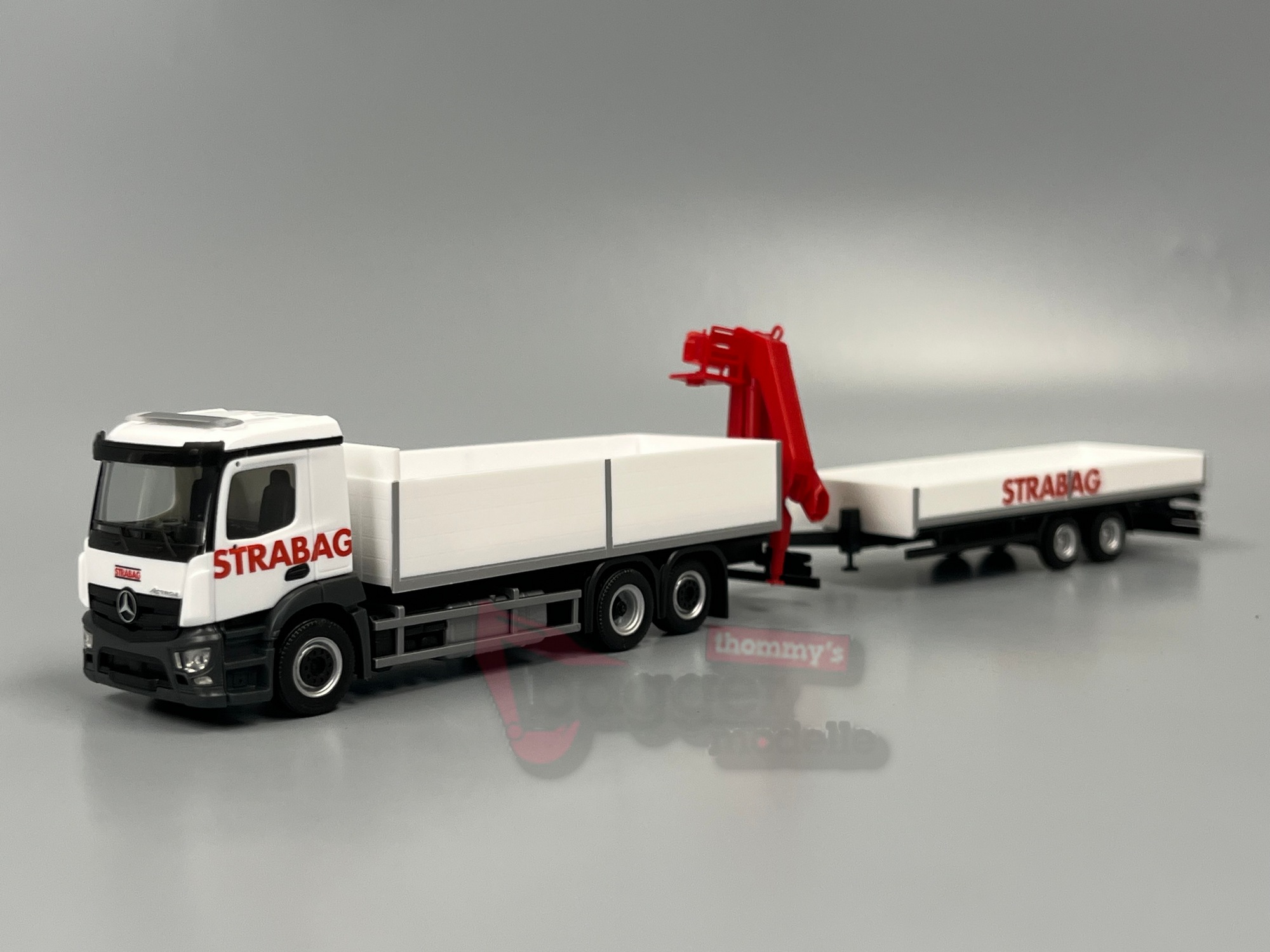 320665 - Herpa -Mercedes-Benz Actros M Baustoff-LKW mit Kran und Tieflade-Anhänger "STRABAG" (Österreich