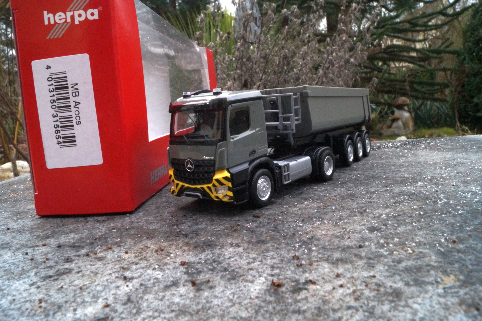 315654 - Herpa - Mercedes-Benz Arocs M Schmitz Cargobull Kipp-Sattelzug mit Stahlmulde, grau / gelb