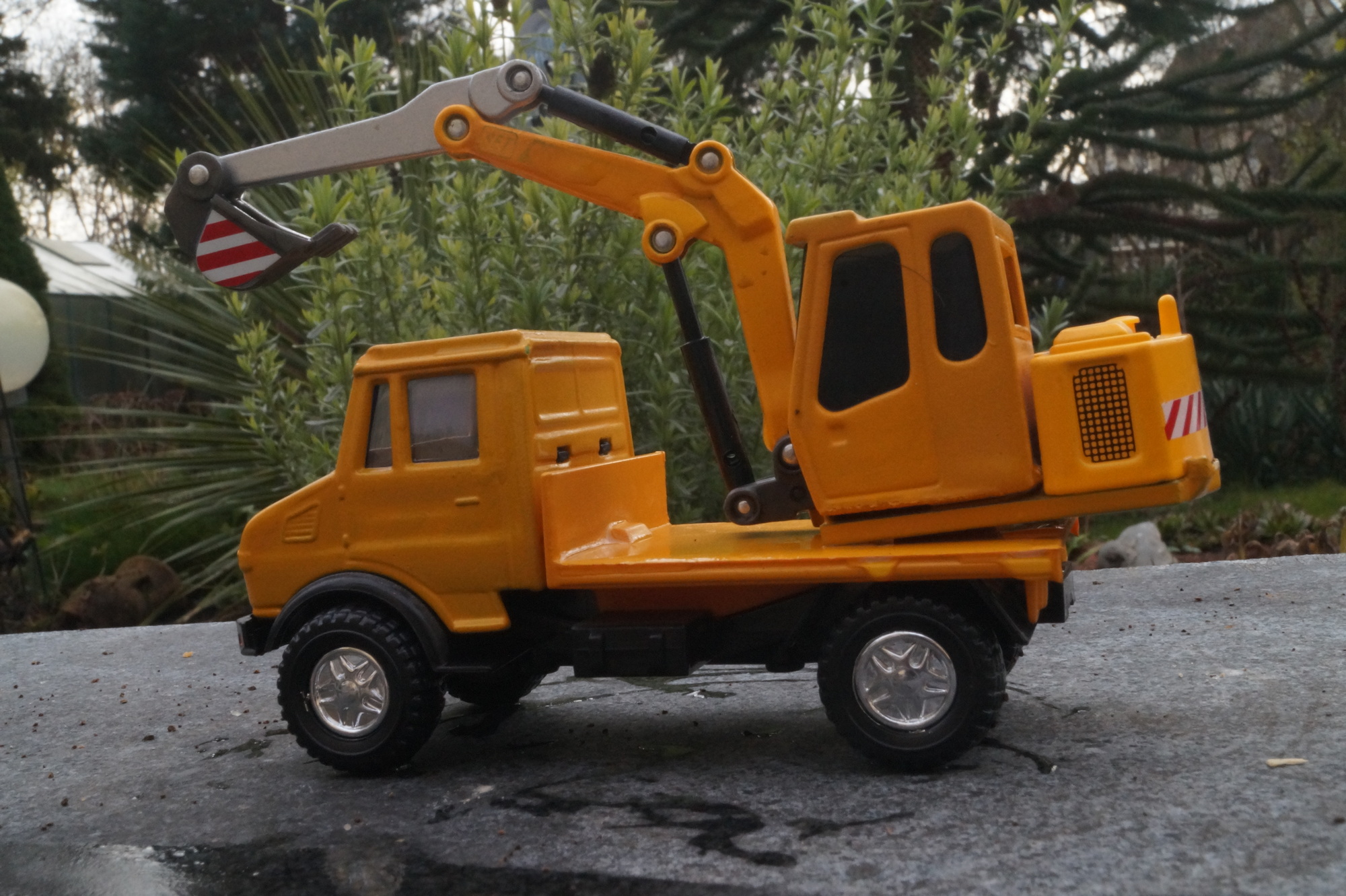 Mercedes Unimog Pritsche mit Bagger
