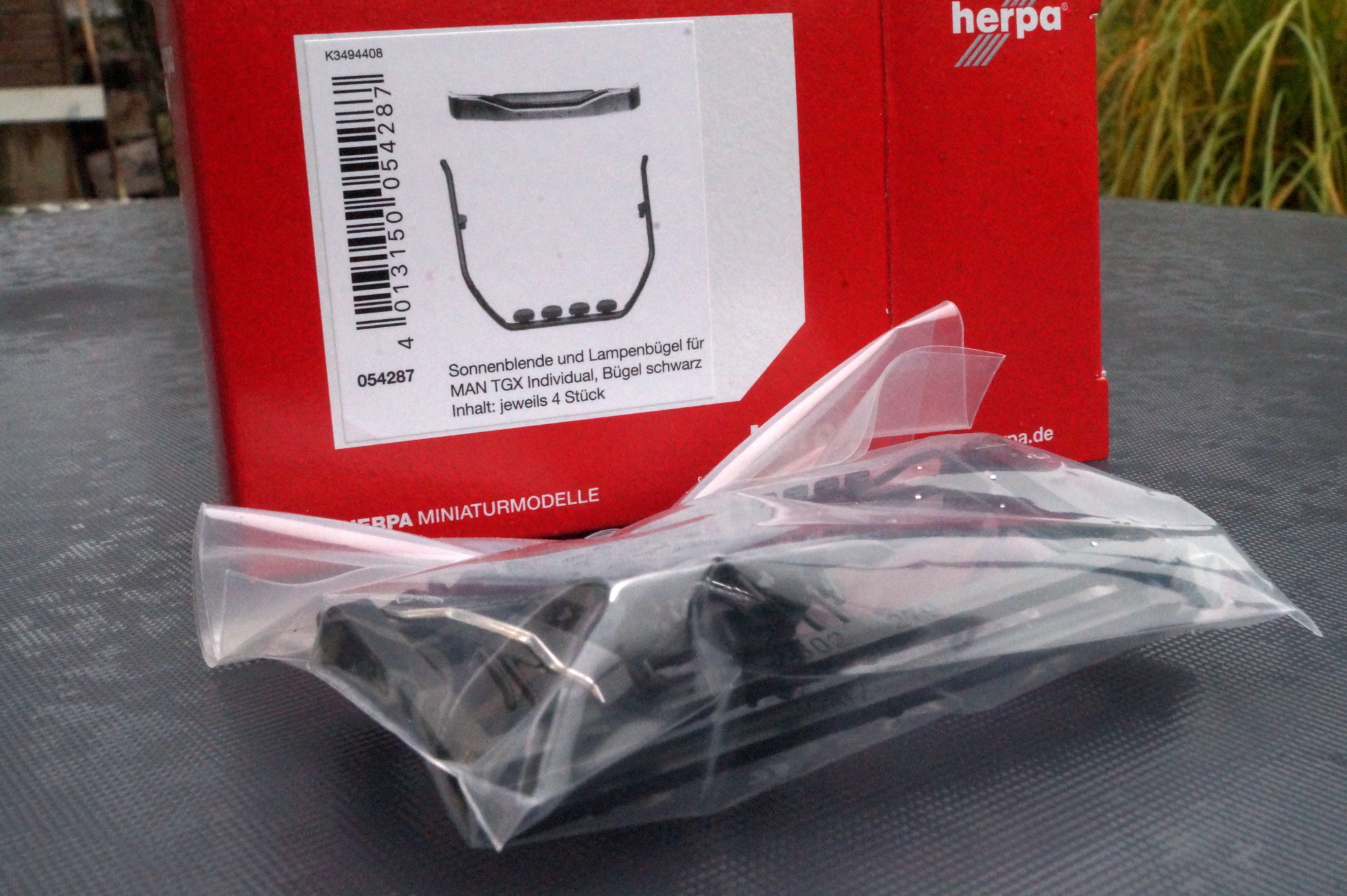 054287 -Herpa - Zubehör Sonnenblende und Lampenbügel für MAN TGX Individual, Bügel schwarz (4 Set)